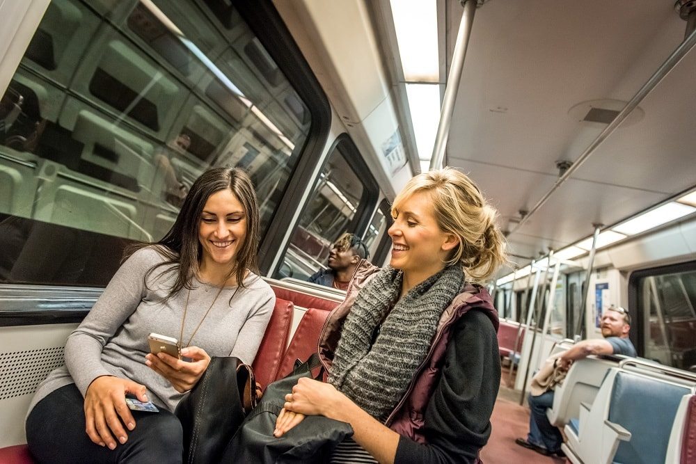 girls on the metro with a smartphone