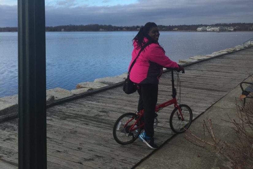 BikeArlington program manager Renee Moore on a folding bike near a body of water.