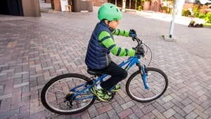 a photo of a young boy in bike gear riding a large bicycle
