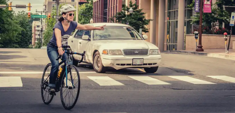 A photo of a woman making a left turn at a crowded intersection