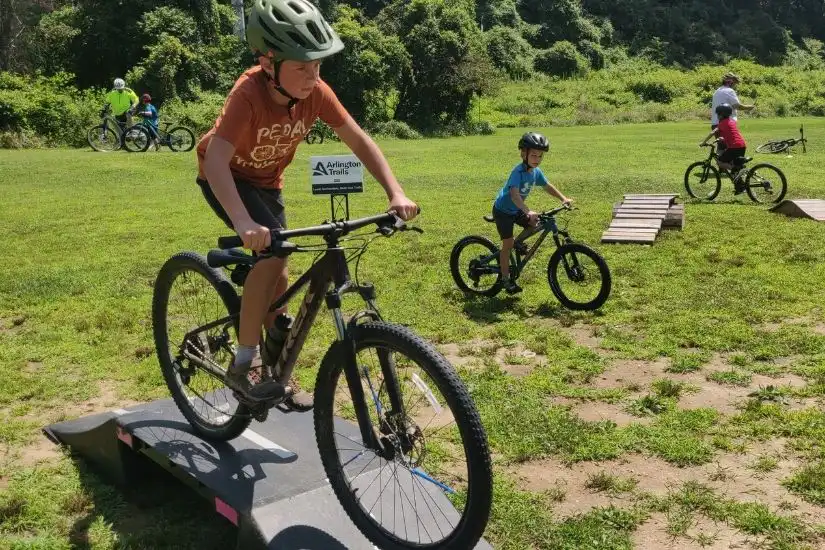 a photo of a boy riding his mountain bike through an obstacle course