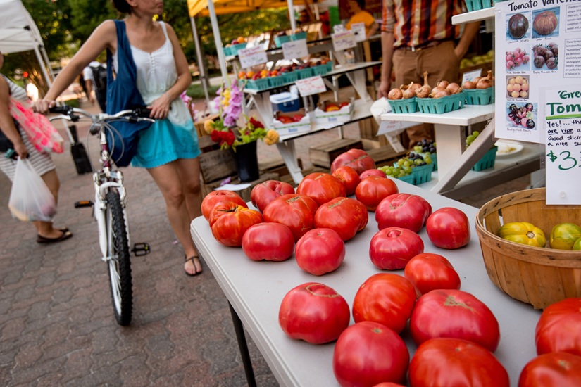 A woman shopping at a farmers market in the summertime