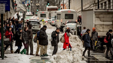 People crossing the street on a snowy day.